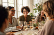 Group of friends having dinner together at home. Women laughing and talking. Selective focus.