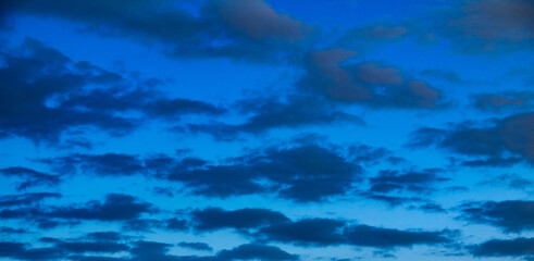 Wall Mural - blue sky with puffy clouds in late evening shot at 84 mm focal length