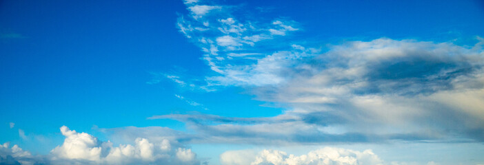 Wall Mural - Blue sky with building clouds shot at 36 mm focal length