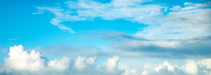 Wall Mural - Aqua blue sky over ocean with building clouds shot at 74 mm focal length
