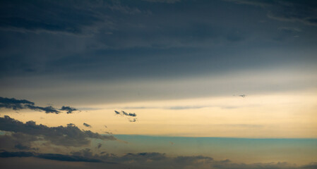 Wall Mural - yellow and green sky with parting clouds after rain at sunrise or sunset shot at 45 mm focal length