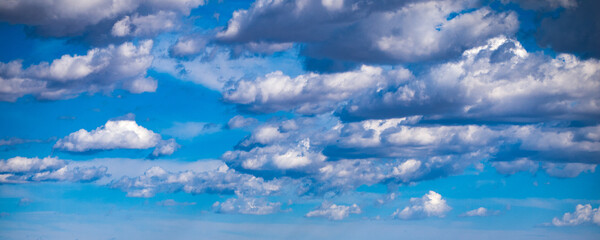 Wall Mural - blue sky with puffy white clouds shot at 90 mm focal length