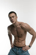 © lizaPolovinko - A young, sexy, athletically built man with no shirt on a gray and white background.