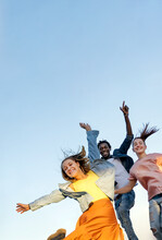 Group Of Happy Multiracial  Friends Smiling And Jumping Over Blue Background - Concept Of Happiness, Freedom, Motion,  And Friendship. 