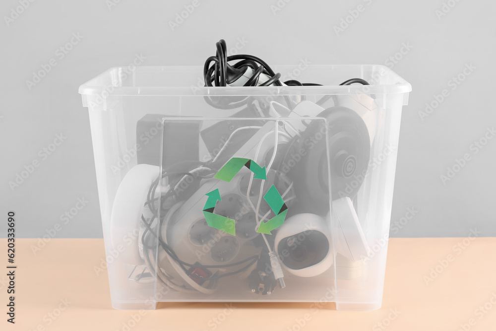 Recycle bin with different household appliances on color background