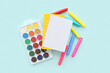 © Pixel-Shot - Blank notebook with different colorful markers and paints on blue background