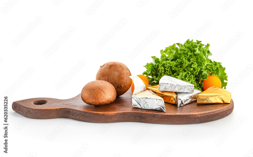 Board with triangles of tasty processed cheese in foil and vegetables on white background