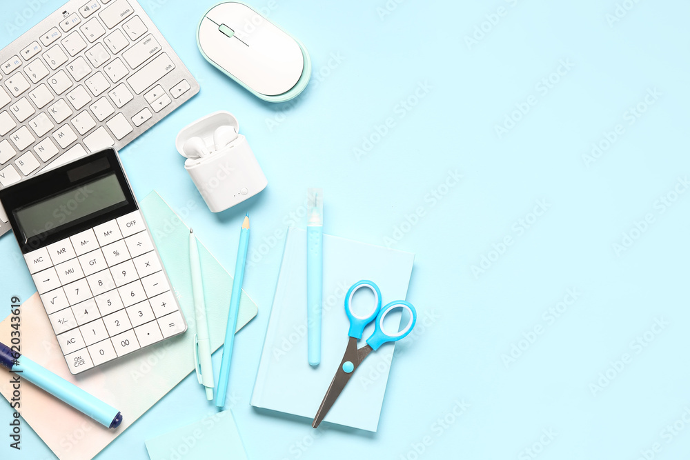 Calculator with stationery, computer keyboard and mouse on blue background