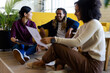 © Wavebreak Media - Three happy diverse casual business colleagues with tablet and document sitting on floor in office