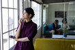 © Wavebreak Media - Thoughtful asian casual businesswoman standing looking out of window in office, copy space