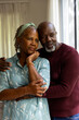 © Wavebreak Media - Thoughtful african american senior couple embracing and talking, looking out of window