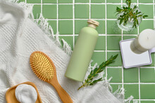 Top View, Flat Lay Of Empty Bottle Decorated With Wooden Comb, Mirror, Scented Candles And White Towel On Green Ceramic Background. Organic Cosmetic For Skin And Hair Care