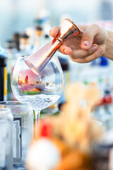 Close-up bartender hand making cocktail at rooftop bar