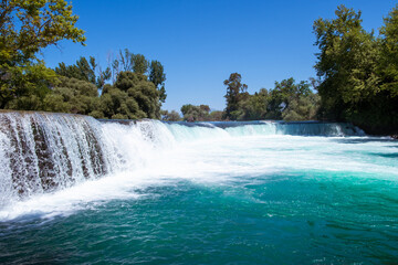 Wall Mural - Manavgat waterfall Manavgat River is near the city of Side, 3 km north of Manavgat in Turkey. A wide stream of water falls from a low height.