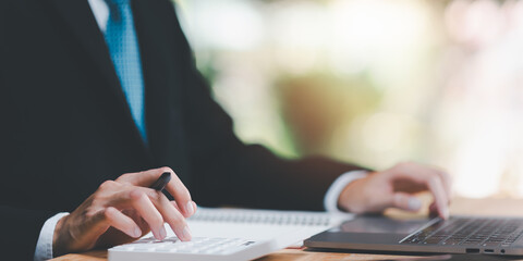 Aufkleber - Businessman using a calculator to calculate numbers ,profit and loss statement review of company performance , effective tax deduction planning for individuals and companies paying tax rates