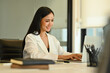 © Prathankarnpap - Successful businesswoman in trendy suit working on laptop computer at her workstation