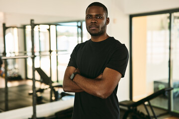 Wall Mural - African American trainer crossing arms in sports center