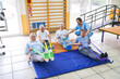 © Robert Kneschke - Therapist assisting elderly people doing workout at rehab center