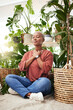 Leinwandbild Motiv Meditation, plant and black woman relax in home for wellness, zen mindset and calm energy. Nature, happy and face of female person meditate on floor with eco friendly ferns, leaves and house plants