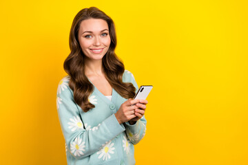 Wall Mural - Photo of cheerful positive woman wear turquoise cardigan chatting modern device empty space isolated yellow color background