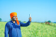 © Pratik Patil - Young indian farmer showing smartphone at wheat field.