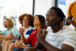 © WavebreakMediaMicro - Group of happy diverse friends sitting on sofa, watching sport on tv