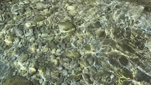 Clear Water With Pebbles And Stones At The Bottom Of Sea.
