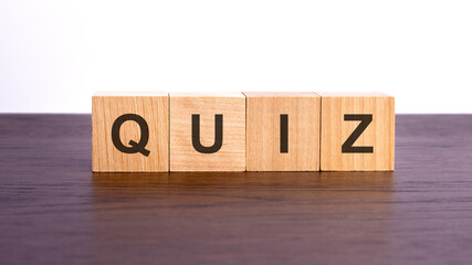 Poster - wooden cubes with text QUIZ on wooden table. financial loss busines concept