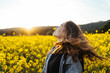 © UCA films/Stocksy - Happy Young woman in flowers field during sunset