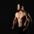 © A Stock Studio - Man with bare muscular torso, studio photo on black background. Bodybuilder.