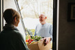 © Melissa Milis Photography/Stocksy - delivery of fresh fruits and vegetables at home of a senior