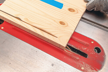 Canvas Print - Cutting a wooden board on a circular machine. View from above. Wood dust.