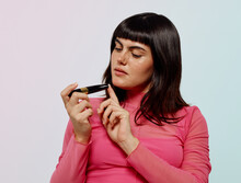 Woman In Pink Checking Cosmetic Vegan Ingredients