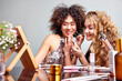 © ALTO IMAGES/Stocksy - Cheerful women applying makeup near mirror