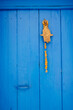 © Michela Ravasio/Stocksy - Fatima hand knocker on blue door