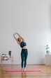 © ISO DUO/Stocksy - Young woman stretching in a yoga studio