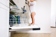 © Maria Manco/Stocksy - Toddler stands on dishwasher