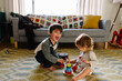 © Maria Manco/Stocksy - siblings play in home together