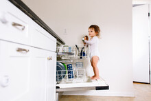 Toddler Stands On Dishwasher