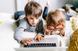 © Maria Manco/Stocksy - Kids play on laptop and reading glasses