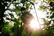 Child Swinging On Swing In Woody Area