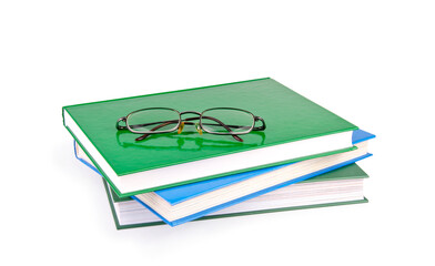 Wall Mural - Reading glasses with books isolated on the white background.
