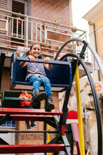 Cheerful Girl Riding Carousel In Amusement Park