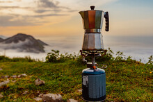 Italian Coffee Maker And Camping Stove In The Mountains At Sunrise. Preparing A Coffee In The Mountains. Trekking And Adventure.
