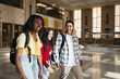 © Pedro Merino/Stocksy - Multiracial group of students with backpacks walking out of class