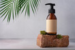 Brown glass bottle standing on moss stone for cosmetic product mock up