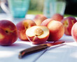 © J.R. PHOTOGRAPHY/Stocksy - sliced Peaches on garden table