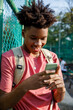 © Jovo Jovanovic/Stocksy - Smiling boy with backpack text messaging using mobile phone
