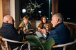 © Daniel Gonzalez/Stocksy - Group of friends talking on terrace during dinner