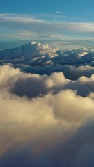 Wall Mural - flying above the clouds. aerial view of clouds at sunrise. traveling by air perfect background. vert